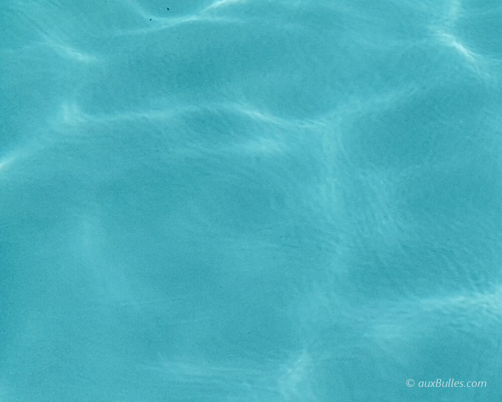 Les reflets du soleil dans l'eau au fond de la piscine