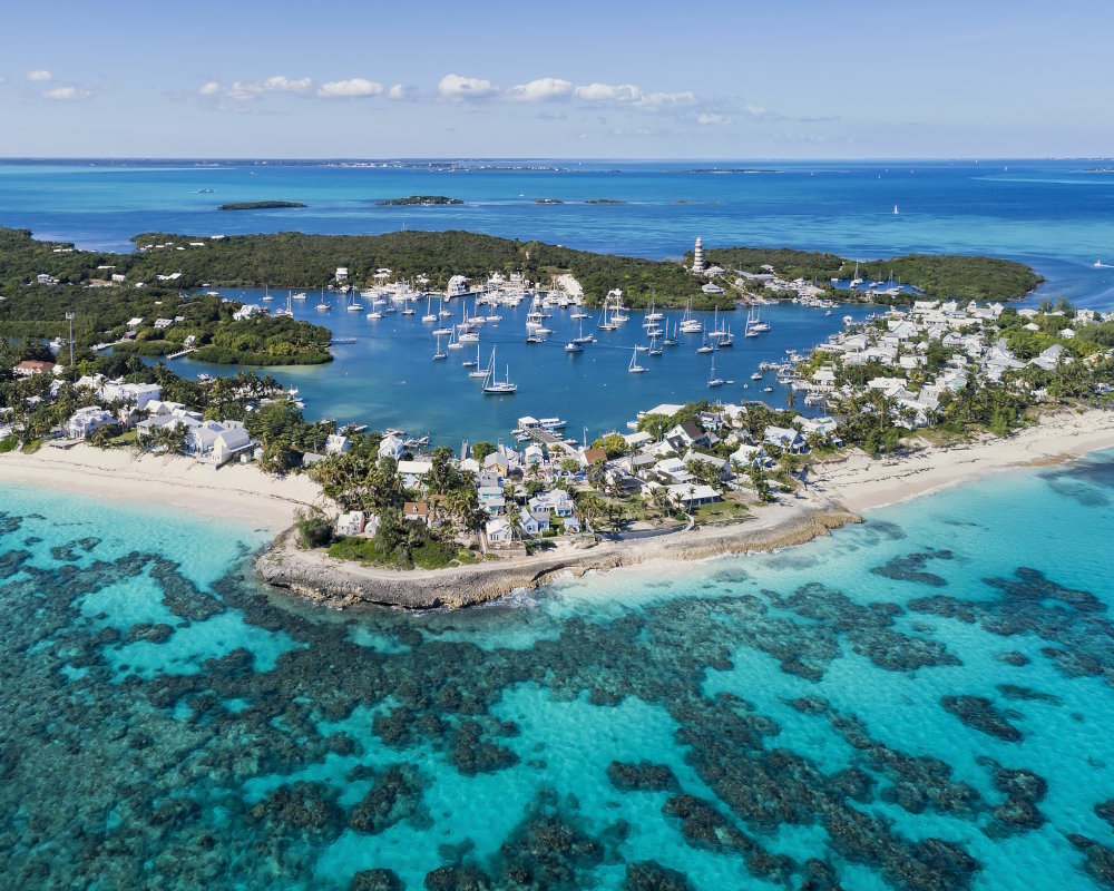 Aerial view of the harbor, beach, and lighthouse in Hope Town on Elbow Cay in the Abacos, Bahamas Aerial view of the harbor, beach, and lighthouse in Hope Town on Elbow Cay in the Abacos, Bahamas
