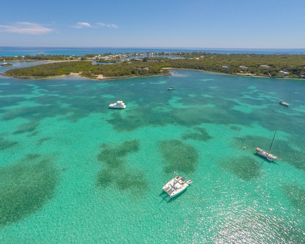 Ambiance maritime aux îles Abacos, avec des bateaux aux mouillage près du célèbre Elbow Reef Lighthouse, emblème de Hope Town