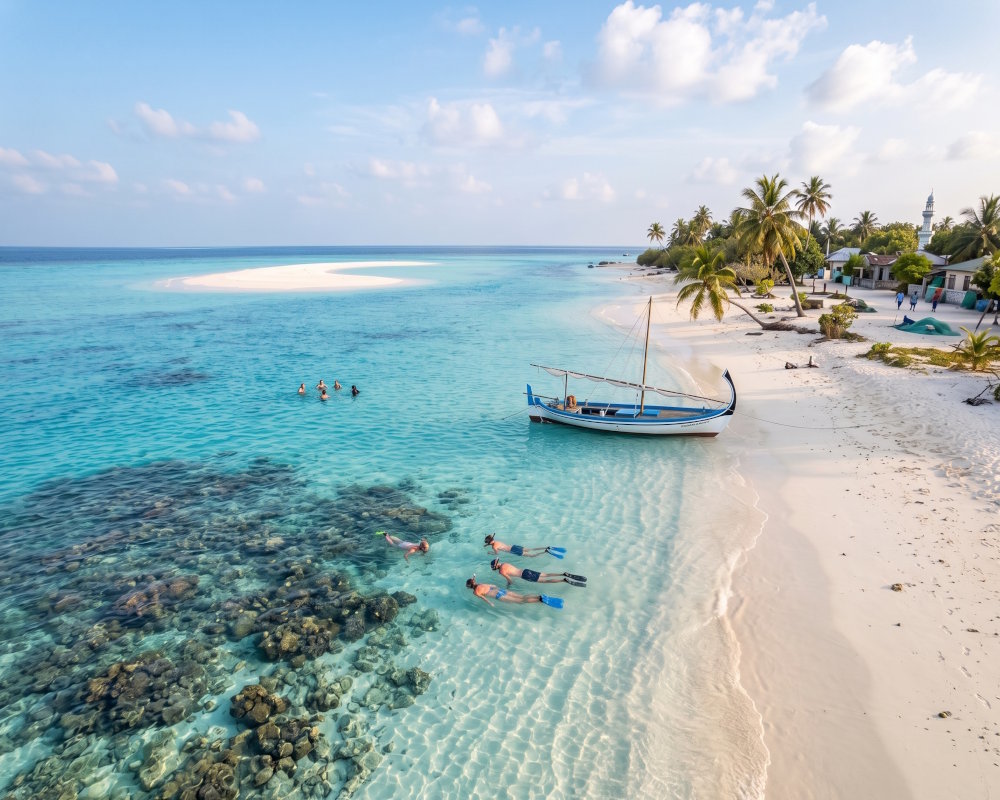 Plage de sable blanc d'une île locale des Maldives, entre snorkeling dans le lagon et banc de sable à l'horizon