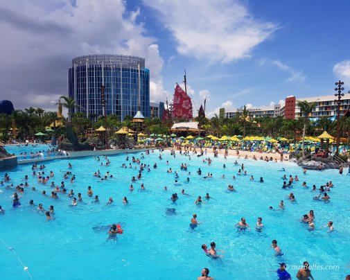L'immense piscine à vagues avec sa grande plage de sable et ses parasols