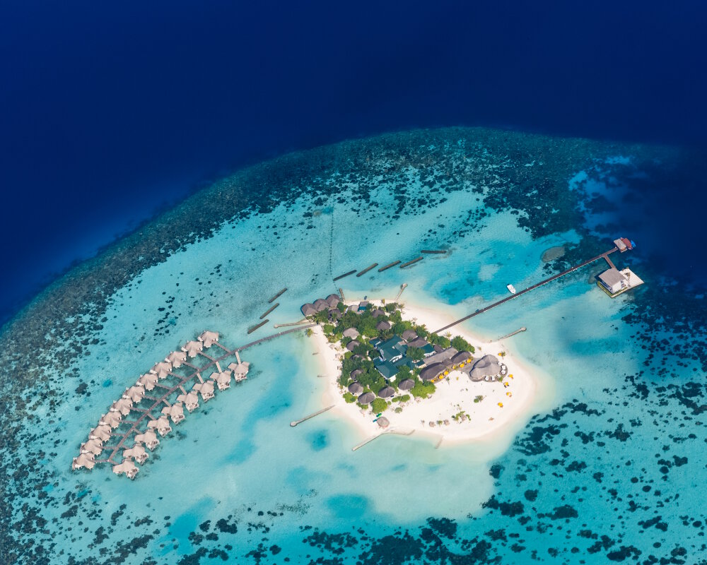 Vue aérienne du resort « Drift Thelu Veliga Retreat » sur la petite île de Theluveligaa entourée par des eaux turquoise dans le Sud de l'atoll d'Ari, aux Maldives Vue aérienne du resort « Drift Thelu Veliga Retreat » sur la petite île de Theluveligaa entourée par des eaux turquoise dans le Sud de l'atoll d'Ari, aux Maldives