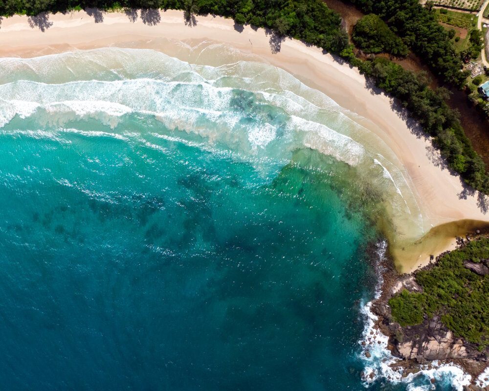 Grand Anse Beach, sur l'île de Mahé, déploie son long ruban de sable doré et ses eaux d'un bleu profond