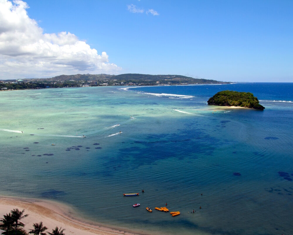 Vue sur la baie Agana avec l'îlot Alupat sur la côte ouest au centre de l'île de Guam Vue sur la baie Agana avec l'îlot Alupat sur la côte ouest au centre de l'île de Guam