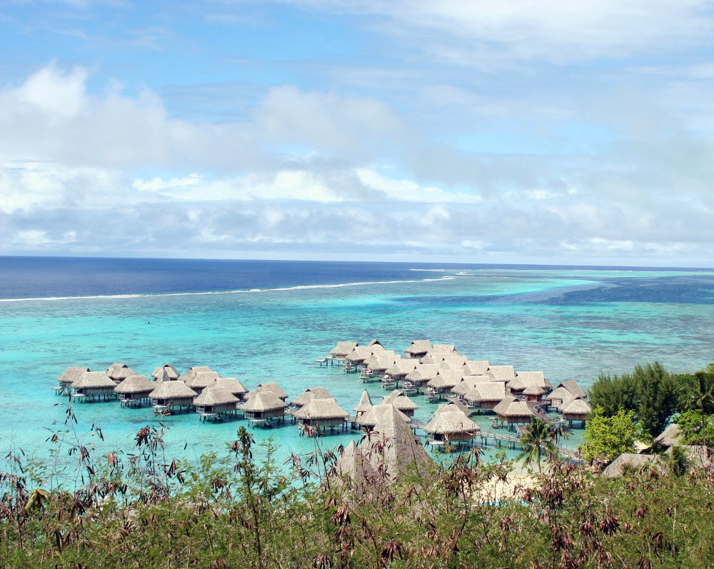 Une vue depuis Toatea sur les eaux turquoises du lagon de Moorea avec ses bungalow sur pilotis