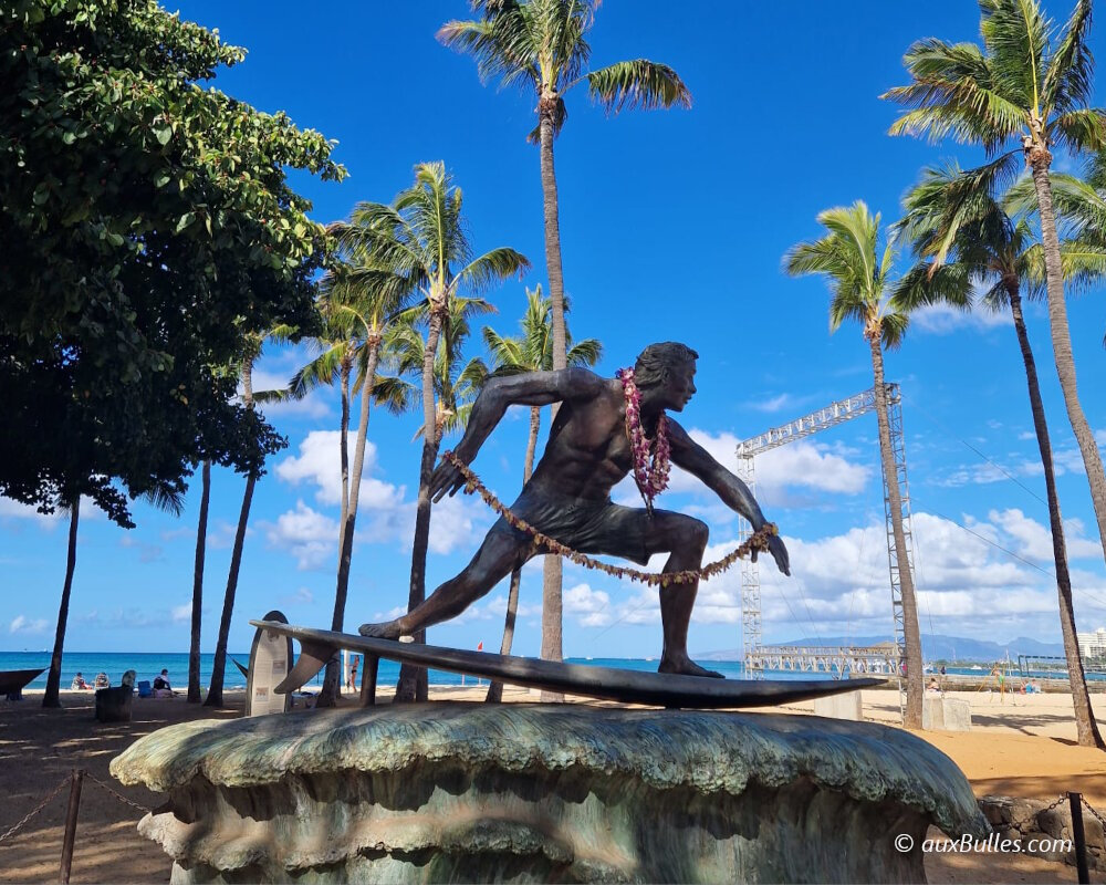 Sur la plage emblématique de Waikiki, à O'ahu, se dresse la statue d'un surfeur, symbole de l'esprit d'Hawaï Sur la plage emblématique de Waikiki, à O'ahu, se dresse la statue d'un surfeur, symbole de l'esprit d'Hawaï