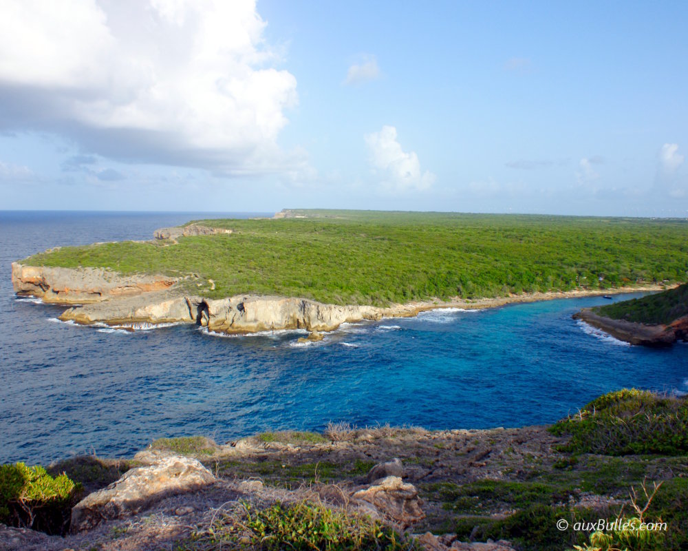 La Porte d'Enfer à Anse-Bertrand, site naturel de la côte nord de la Guadeloupe, est une baie protégée par des falaises calcaires et un lagon aux eaux calmes et turquoise, bordé par l'océan Atlantique La Porte d'Enfer à Anse-Bertrand, site naturel de la côte nord de la Guadeloupe, est une baie protégée par des falaises calcaires et un lagon aux eaux calmes et turquoise, bordé par l'océan Atlantique