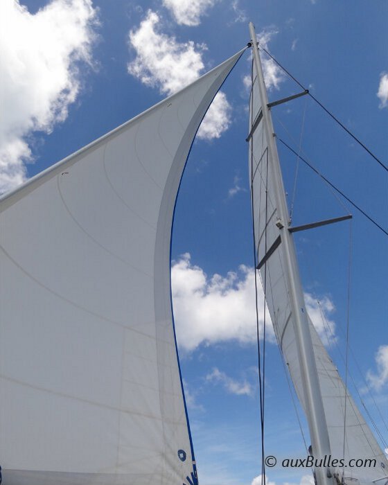 Les voiles blanches d’un voilier voguent sur le ciel bleu de la République Dominicaine Les voiles blanches d’un voilier voguent sur le ciel bleu de la République Dominicaine