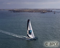 Passage de la ligne de départ du Trophée Jules Verne par Banque Populaire V, le maxi trimaran de Loïck Peyron