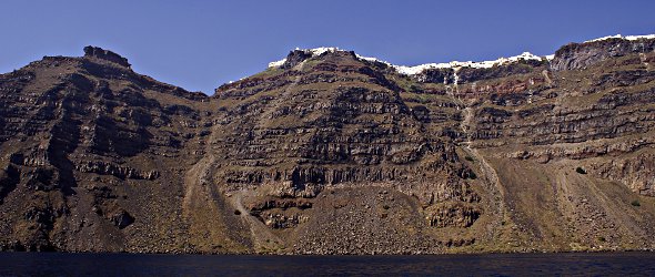 Les falaises verticales impressionnantes se dressent autour de la caldera. Au sommet, les villages perchés sont éclatants de blancheur ! Les falaises verticales impressionnantes se dressent autour de la caldera. Au sommet, les villages perchés sont éclatants de blancheur !