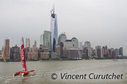 Francis Joyon sur son maxi trimaran IDEC navigue face à la skyline de New York lors de son départ pour le record de la traversée de l'Atlantique Nord.