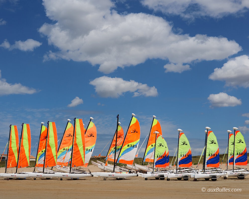 Les catamarans attendent sur la plage avec les voiles déjà gréées