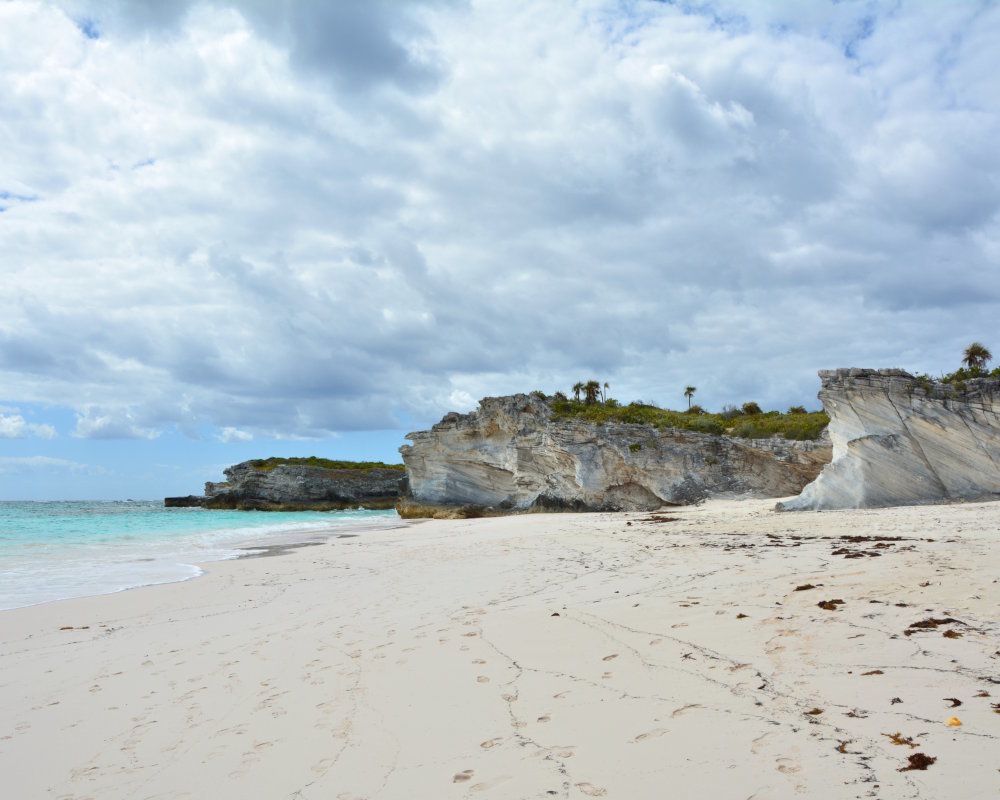 Une plage déserte de sable blanc au pied des falaises sur l'île d'Eleuthera